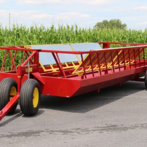 Red livestock feed wagon near cornfield